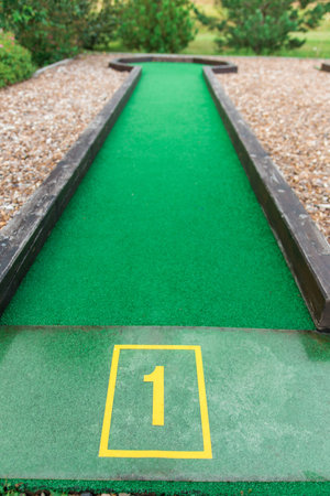 mini golf course number 1. an artificial structure with wooden beads among the mound of gravel