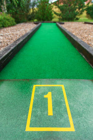 mini golf course number 1. an artificial structure with wooden beads among the mound of gravelの写真素材