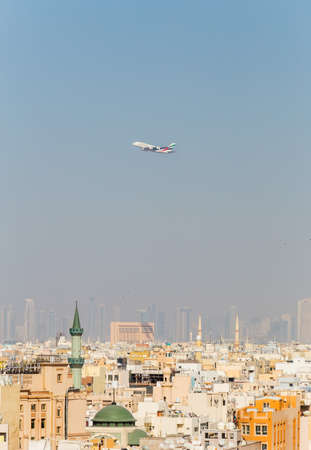 Dubai, UAE February 14, 2018: Airbus a380 airline Emirates takes off on the background of houses and cityscapeのeditorial素材