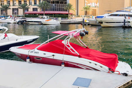 Dubai, UAE February 17, 2018 modern motor boat at the pier in the picturesque area of the promenade of Dubai Marinaのeditorial素材