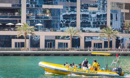 Dubai, UAE February 17, 2018: yellow inflatable motor boat with tourists on the waterfront...