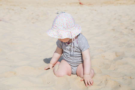 Little baby girl sitting on the sandの写真素材