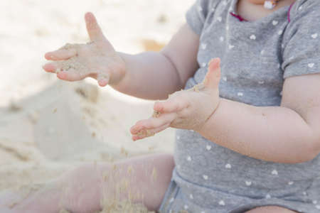 Little baby girl sitting on the sandの写真素材