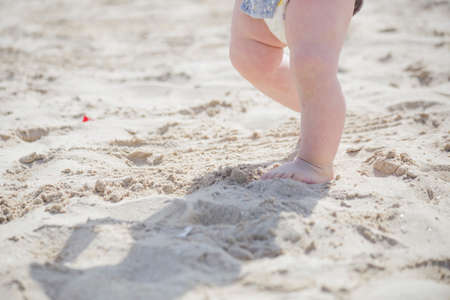 children's feet on the sand in summerの写真素材