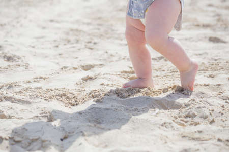 children's feet on the sand in summerの写真素材