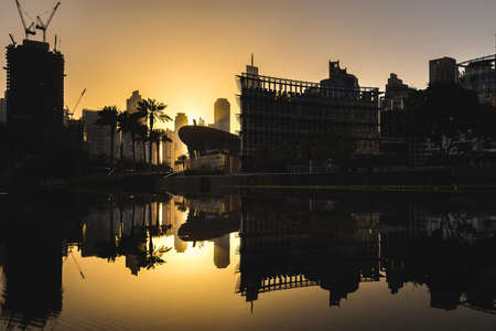 skyscrapers and palms reflected in the water against the sunset in Dubaiの写真素材