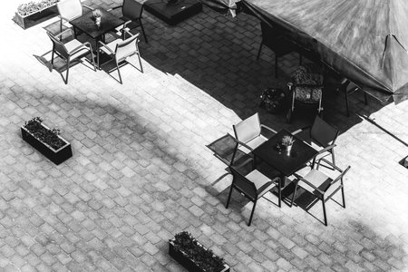 table and chairs in an outdoor cafe. Black and white photography. View from aboveの写真素材