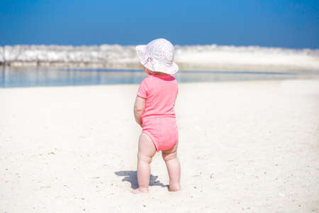 Little beautiful girl baby in panama on the beach with white sandの写真素材
