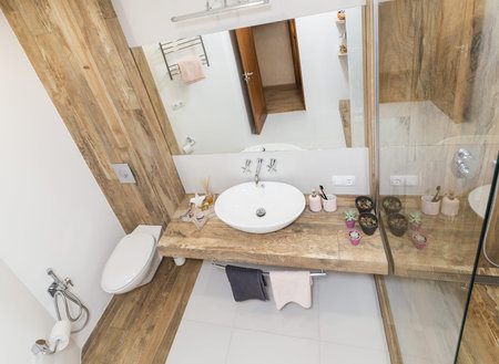 Modern interior of the bathroom. The washbasin is made of white massive shell on the table top made of marble in the color of wood. Minimalism and simplicity in a bright functional interiorの写真素材