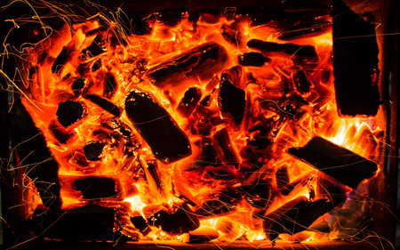 bright orange sparks from a campfire on long exposure and smoldering coals. dynamics lines traces.