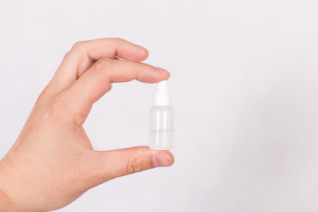 A small tube with a colorless liquid in a hand on a white background