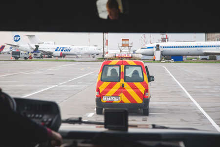 Ufa, Russia. May 19, 2018: Follow me car at the airport accompanies the passenger shuttle to the planeのeditorial素材