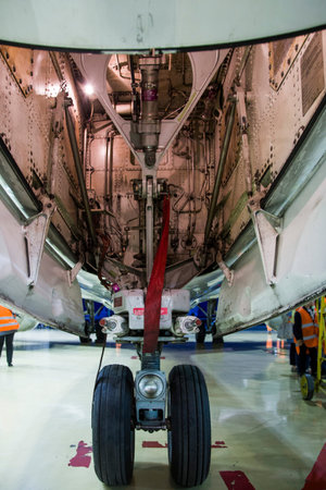 Front landing gear of a passenger airplane close-up in a hangar on maintenance