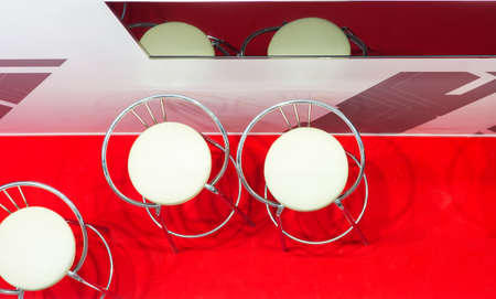 Interior decoration. White bar stools on the red floor covering. View from aboveの写真素材