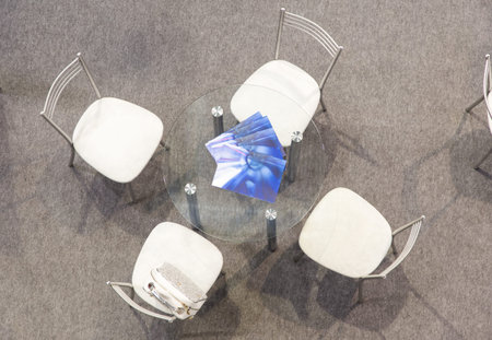 A transparent glass round table and four chairs on a gray carpet. View from aboveの写真素材