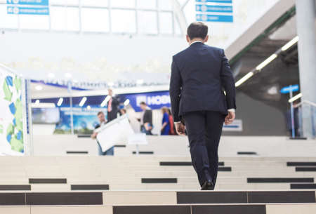 A businessman in a suit climbs the stairs in the business center. The concept of career ladder and successの写真素材