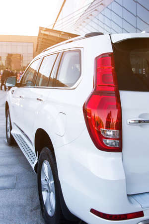 Large white SUV on the background of a glass buildingの写真素材