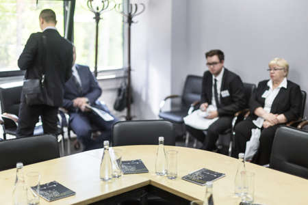 Ufa, Russia 24 May 2018: Business Forum - Oil and Technology. Bottles of water and glasses on the empty meeting table and people in the background. Business conceptのeditorial素材