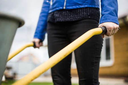 the woman is holding a building wheelbarrow. garden workの写真素材