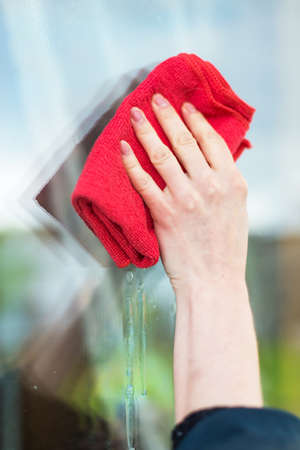 women's hands cleaning windows with special rag and windshield wiperの写真素材