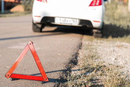A car with a breakdown alongside the road. warning triangle