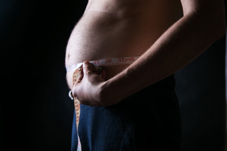 Fat man holding a measuring tape. Weight Loss. obesityの写真素材