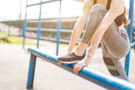 beautiful girl in sports uniform, doing exercises on the street, running around, drinking water. Healthy way of life, an infused figure.の写真素材