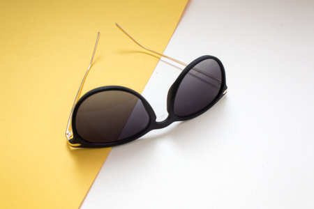 blue sunglasses on pink and yellow background. minimalism and summer fashion for the beach