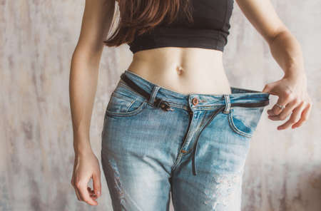 Slimming woman wearing big pants. before and after losing excess weight.の写真素材