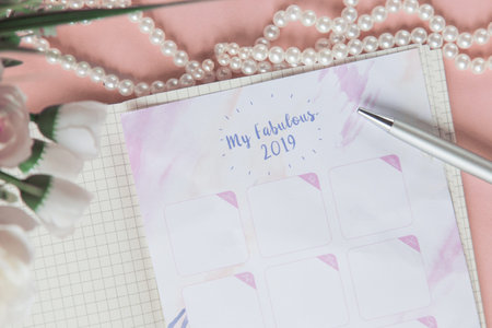Calendar for 2019 on the office desk in a notebook. Plans and goals for the new year. Top view layout on pink backgroundの写真素材