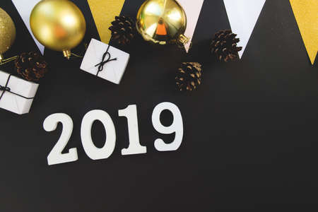 Happy New Year's layout. numbers 2019 notepad and free space for text. Christmas decorations, xmas toys, gold stars, gifts. Goals for the new year. mock up on black backround, flatlayの写真素材