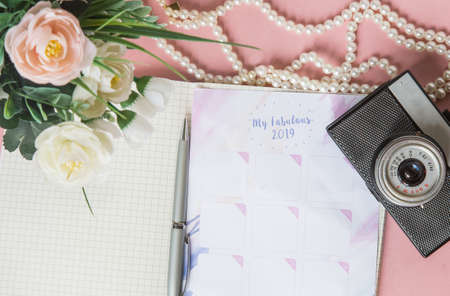 Calendar for 2019 on the office desk in a notebook. Plans and goals for the new year. Top view layout on pink backgroundの写真素材