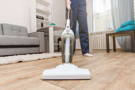 Cleaning service with professional equipment during work. professiona carpet dry cleaning, sofa dry cleaning, window and floor washing. women in uniform, overalls and rubber gloves.の写真素材