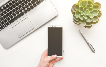 Woman hands holding empty screen of smartphone on wood desk work.の写真素材