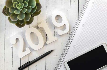 Happy New Year's layout. numbers 2019 notepad and free space for text. Christmas decorations, Christmas toys, gold stars. Goals for the new year. mock up mobile phoneの写真素材