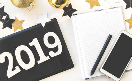 Happy New Year's layout. numbers 2019 notepad and free space for text. Christmas decorations, Christmas toys, gold stars. Goals for the new year. mock up mobile phoneの写真素材