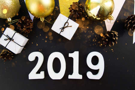 Happy New Years layout. numbers 2019 notepad and free space for text. Christmas decorations, Christmas toys, gold stars, gifts. Goals for the new year. mock up on black backroundの写真素材
