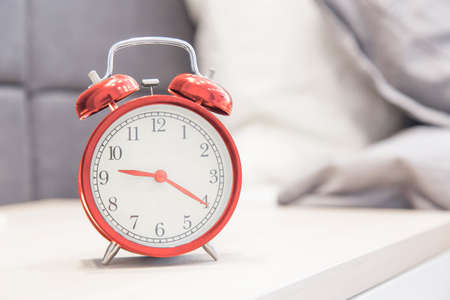 alarm clock on the nightstand beside the bed. Interior bedroomの写真素材