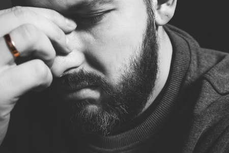 married ring on a mans finger. Sad portrait of a man holding his head. family problems, litter and violenceの写真素材