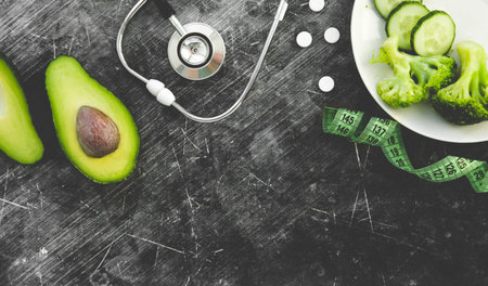 doctor nutritionist table. Healthy and healthy food, broccoli, pickers and avacado. Stethoscope and...