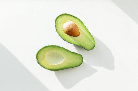 ripe green avocado on white background . slimming and nutrition. flat lay top view.