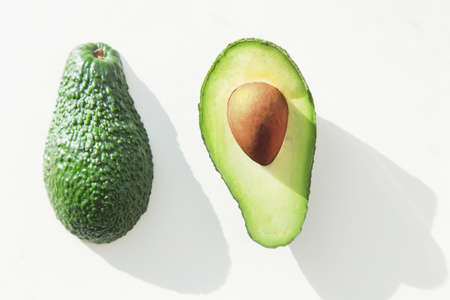 ripe green avocado on white background . slimming and nutrition. flat lay top viewの写真素材