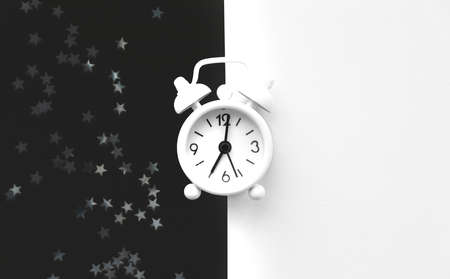 White table clock, alarm on black white background, top view. Good morning. Minimalismの写真素材