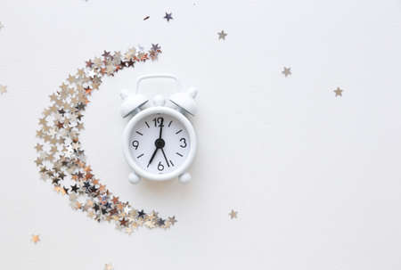 White table clock, top view alarm clock and small starsの写真素材