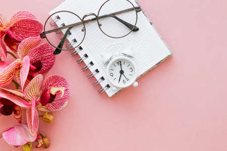 White table clock, alarm clock on a bright background, top view. Break at work in the office. Paper, flatlayの写真素材