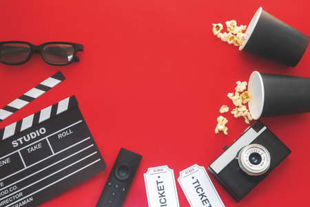 Cinema party concept. movie tickets, clapperboard, pop corn and 3d glasses in a red