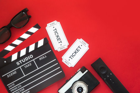 Cinema party concept. movie tickets, clapperboard, pop corn and 3d glasses in a redの写真素材