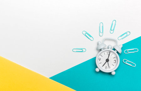 Alarm clock on colorful paper