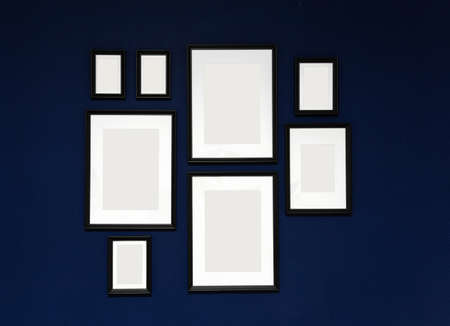 Composition of 8 black photo frames on a blue wallの写真素材