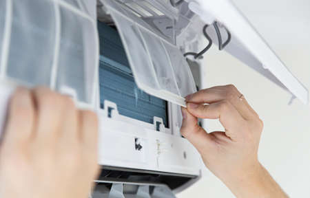 Male technician cleaning air conditioner indoors.の写真素材